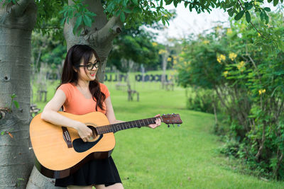 Full length of woman playing guitar