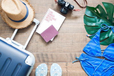 High angle view of luggage with passport and camera on floor representing travel