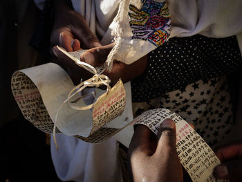 Midsection of person holding paper with text