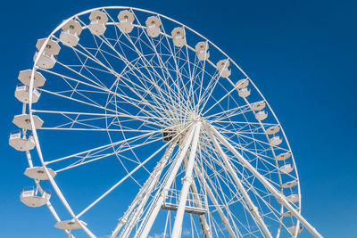 Low angle view of ferris wheel against blue sky