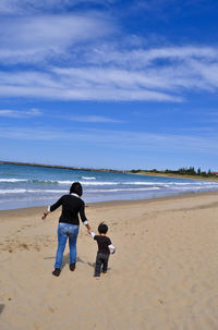 Rear view of boys on beach