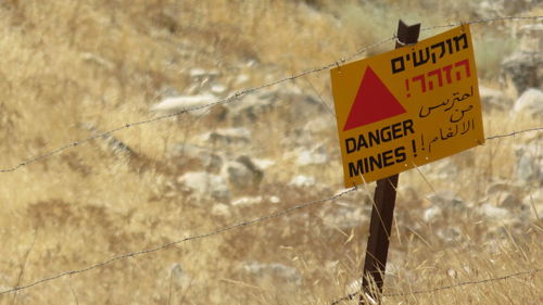 High angle view of warning sign on fence