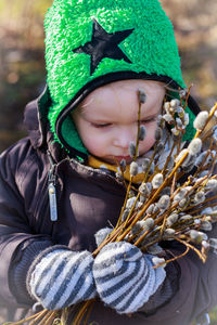 Boy in warm clothes holding plant