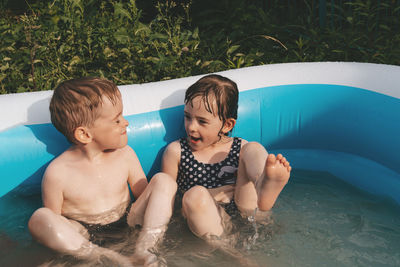 Cheerful happy children in the pool. friends spend summer leisure together on a hot day. copy space