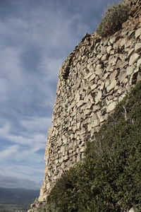 Low angle view of stone wall against sky