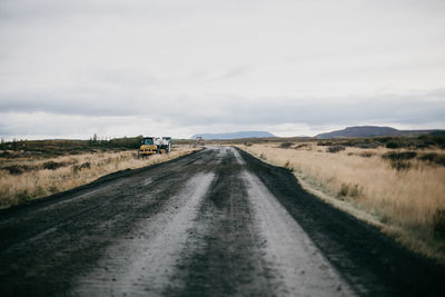 Road amidst field against sky