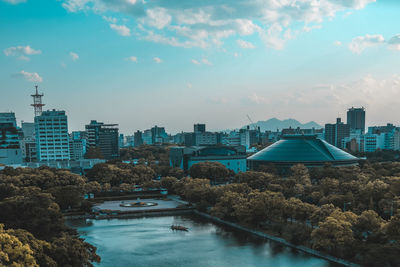 River amidst buildings in city against sky