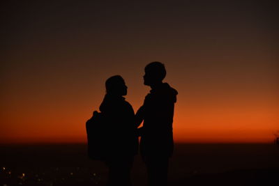 Silhouette man standing against sky during sunset