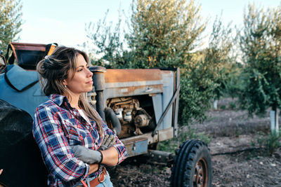 Young woman looking at camera while sitting on land