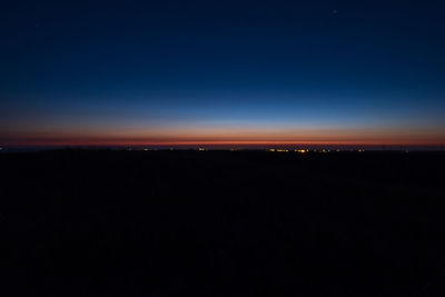 Silhouette landscape against clear sky at night