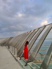 Rear view of people walking on beach against sky