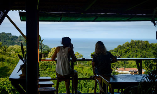 Rear view of man and woman sitting against sky