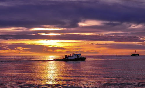 Silhouette ship sailing on sea against sky during sunset