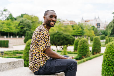 Positive afro american stylish man in european city with electronic device