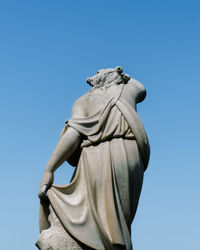 Low angle view of statue against clear blue sky