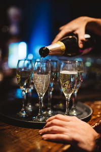 Midsection of woman holding wine glass on table