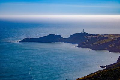 Scenic view of sea and mountains against sky