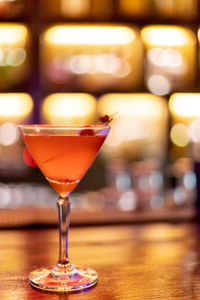 Strawberry juice mixed with alcohol soda in a cocktail glass in front of the vintage bar