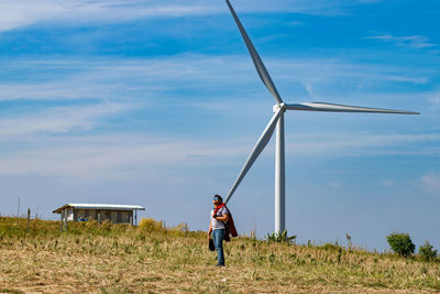 Full length of man photographing on field against sky