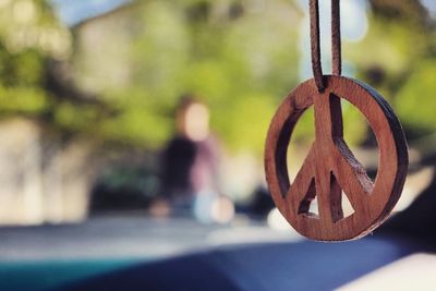 Close-up of peace symbol hanging in car