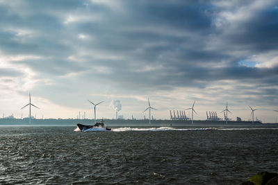 Sailboats in sea against sky