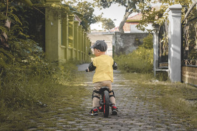 Portrait of cute 2 year old toddler riding a push bike