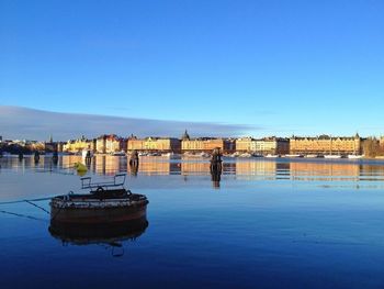 Boats in calm sea against clear sky