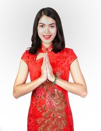 Portrait of a smiling young woman against white background