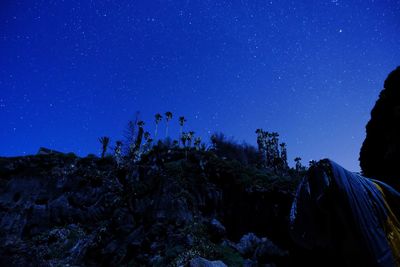 Scenic view of rocks against blue sky at night