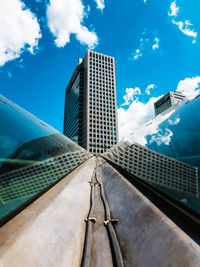 Low angle view of modern building against cloudy sky