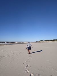 Rear view of man walking on beach