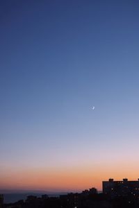 Scenic view of city against clear sky at sunset