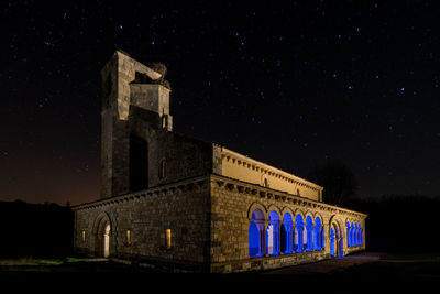 Low angle view of illuminated building against sky at night