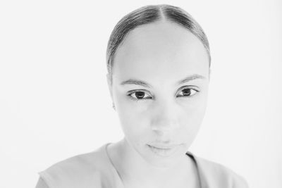 Close-up portrait of young woman against white background