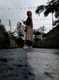 Full length of woman standing on street in city