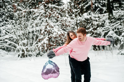 Girl and woman with umbrella on snow during winter