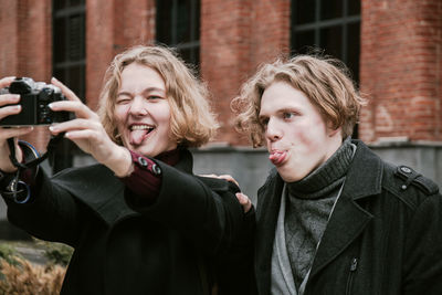 Close-up of friends photographing in city