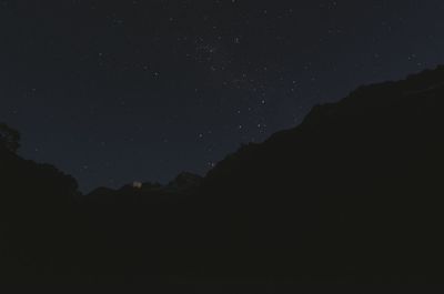 Silhouette mountain against sky at night