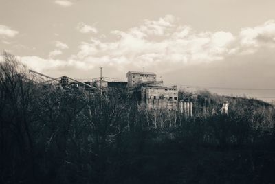 Buildings by sea against sky