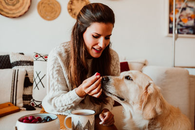Close-up of woman feeding dog at home