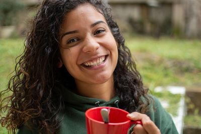 Portrait of a smiling young woman drinking drink