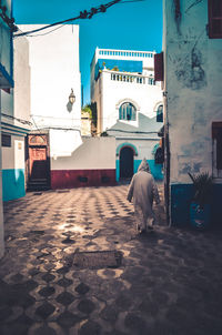 Rear view of man walking on street in city