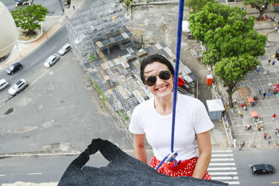 Caucasian woman wearing hero costume descending a tall building in rappel. salvador bahia brazil.