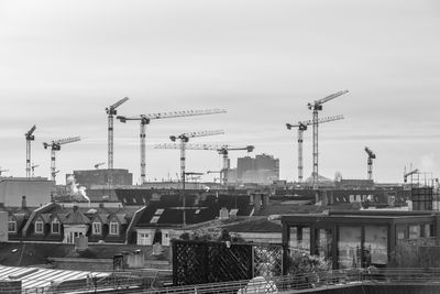 Cranes at construction site against sky