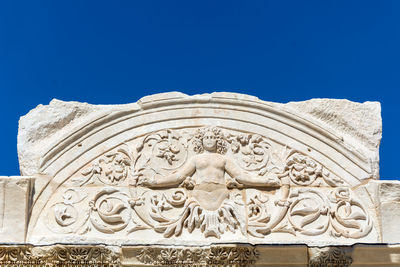 Low angle view of sculpture against clear blue sky