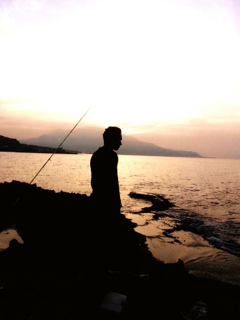 sunset, silhouette, water, sea, tranquility, tranquil scene, standing, scenics, beauty in nature, leisure activity, lifestyles, sky, nature, idyllic, rear view, clear sky, men, horizon over water