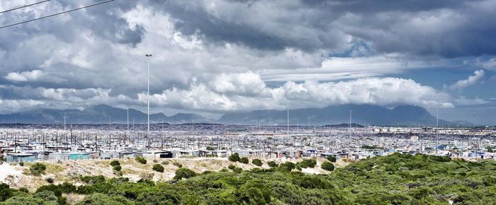 High angle view of city by sea against sky