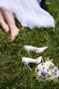 Low section of woman standing on grassy field