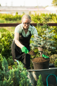 Woman standing by potted plant