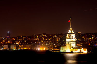 Illuminated buildings against sky at night